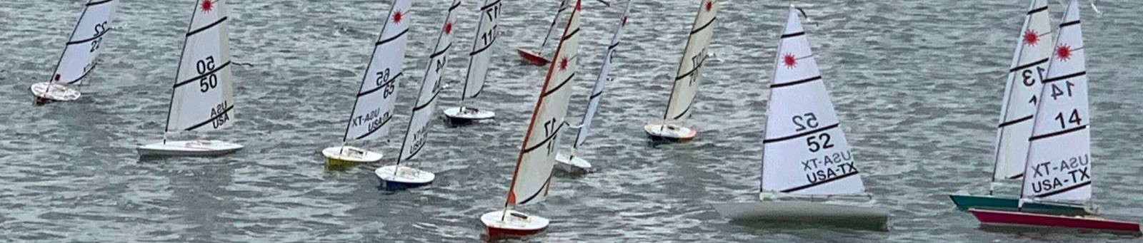 RC Laser fleet racing close together on the water